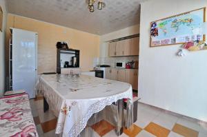 a kitchen with a table in the middle of a room at Apple Hostel Cholpon Ata in Cholpon-Ata +18 photos