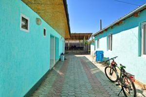 a bike parked next to a blue building at Apple Hostel Cholpon Ata in Cholpon-Ata