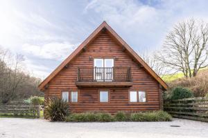 a log cabin with a balcony on top of it at Hillview in Little Petherick