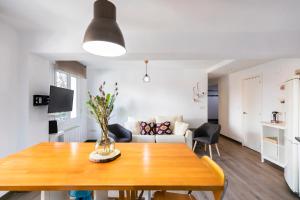 a living room with a table and a couch at AkomodaT en apartamento luminoso junto al paseo de la ría in Bilbao