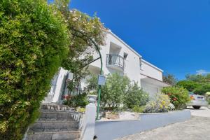 een wit huis met een trap en een balkon bij Rina Vacation home in Trogir