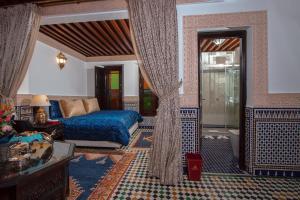 a bedroom with a bed and a living room at Riad Myra in Fès