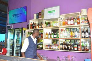 a man standing at a bar in a liquor store at HOTEL SENATE JUJA in Thika