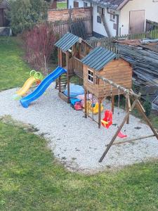 un parque infantil con una casa y un tobogán en Apartmán Gabriela en Roudné
