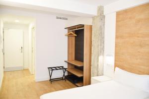 een slaapkamer met een bed en een boekenplank bij Uma Suites Ondarreta in San Sebastian