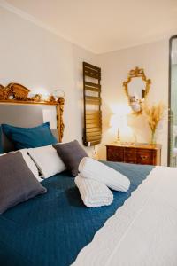 a large bed with blue and white pillows on it at Suite de Diane - Premiere conciergerie in Nîmes