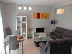 a living room with a couch and a table at APARTAMENTOS TURISTICOS LAS CINCO JOYAS in Linares