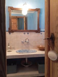 y baño con lavabo y espejo. en Amapola Alojamiento Rural, en Zuheros