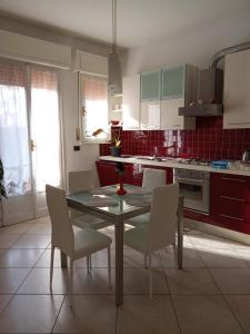 a kitchen with a table and chairs and red tiles at M. BINI B&B in Bologna