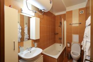 a bathroom with a sink and a toilet and a tub at Pirin Golf Mountain View Retreat in Razlog