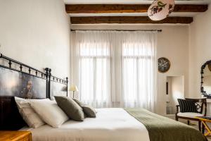 een slaapkamer met een groot wit bed met witte kussens bij Santa Giustina Palace R&R in Venetië