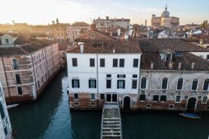 uitzicht op een rivier met gebouwen in een stad bij Santa Giustina Palace R&R in Venetië
