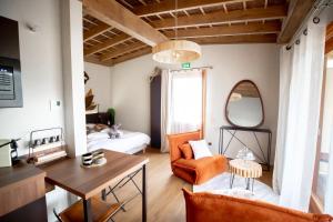 a living room with an orange chair and a couch at Les Nuits de Thoiry in Thoiry