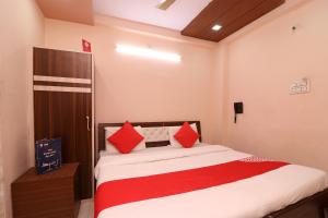 1 dormitorio con 1 cama con almohadas rojas en Flagship Hotel Royal Paradise en Tīrath