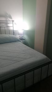 a bedroom with a white bed with a lamp at amaRE in Reggio Emilia +4 photos