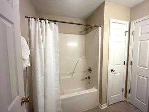 baño con ducha con cortina blanca en Entire home in Foley, Alabama, United States en Foley