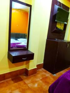 um espelho numa parede ao lado de uma cómoda com uma cómoda em Goroomgo Sahoo Palace Puri Near Sea Beach em Puri