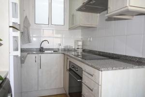 a white kitchen with a sink and a stove at My Home in Igualada in Igualada