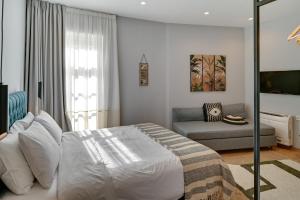 Habitación blanca con cama y sofá en 43 Ave, en Ioannina