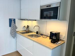 a small kitchen with a sink and a microwave at Mesipesa Green Lodge in Laagna