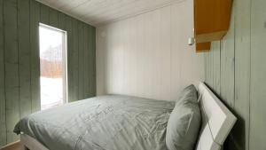 Posto letto in una piccola camera con finestra di Mesipesa Green Lodge a Laagna