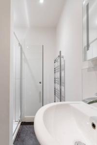 a white bathroom with a sink and a shower at Modern apartment with terrace in Bristol