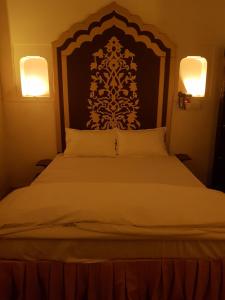 - un lit avec une grande tête de lit dans une chambre dans l'établissement Chhoti Kothi - A Heritage Homestay by the Ganges, à Prayagraj
