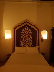 - une chambre dotée d'un grand lit avec deux lumières dans l'établissement Chhoti Kothi - A Heritage Homestay by the Ganges, à Prayagraj