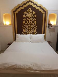 - une chambre dotée d'un grand lit avec une tête de lit en noir et or dans l'établissement Chhoti Kothi - A Heritage Homestay by the Ganges, à Prayagraj