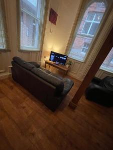 a living room with a couch and a television at Mezz Apartment Four in Hull