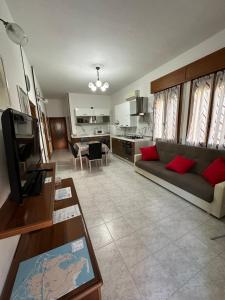 uma sala de estar com um sofá e uma cozinha em Appartamento Annesca - Delta del Po em Porto Tolle