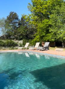 una piscina con 2 tumbonas junto a en Los Narcisos en San Antonio de Areco