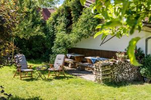 - un jardin avec deux chaises, une table et une table de pique-nique dans l'établissement Beim Paulfischer, à Chieming