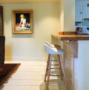 una cocina con una barra con una pintura en la pared en Luxury Cottage, close to Quay. Pretty Courtyard., en Blakeney