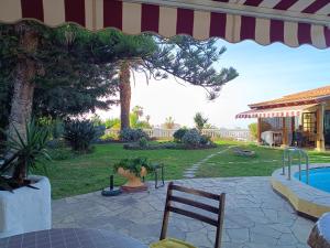 een patio met een tafel, een stoel en een zwembad bij Tiny House: The Housje in Puerto de la Cruz