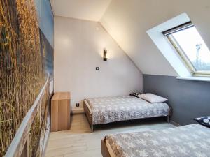 1 dormitorio en el ático con 2 camas y ventana en Apartament II Gdańsk - Apartamenty w Górach i nad Morzem, en Gdansk