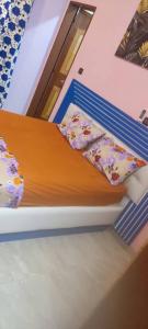 un letto con cuscini e lenzuola in una stanza di Passion RÉSIDENCE a Ouagadougou