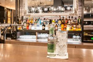 a bottle and glass sitting on a table in a bar at Premier Inn Köln City Mediapark in Cologne