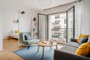 a living room with a couch and a table at Edgar Suites Levallois – Jules Verne in Levallois-Perret