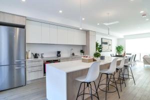 a kitchen with white cabinets and a bar with stools at Luxury Resort Villa in Muskoka in Gravenhurst