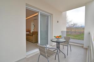 Un comedor con mesa y sillas y una sala de estar. en Evas Rooms, en Neoi Poroi 33 fotos más