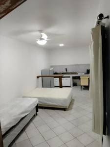 a bedroom with two beds and a desk with a table at Flats do Cordeiro in Cabo Frio +8 photos