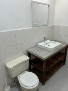 a bathroom with a white toilet and a sink at Villa Maria in Port-of-Spain