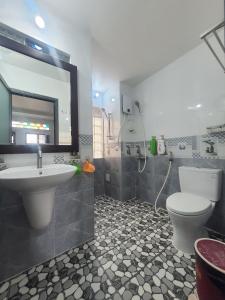 uma casa de banho com um lavatório, um WC e um espelho. em Homestay Khoa Chaudoc em Chau Doc