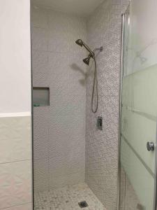 W łazience znajduje się prysznic ze szklanymi drzwiami. w obiekcie Villa Maria w mieście Port-of-Spain