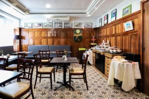 un restaurante con paredes de madera, mesas y sillas en Logis Hôtel d'Angleterre, en Saint-Calais