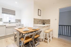 eine Küche und ein Esszimmer mit einem Holztisch und Stühlen in der Unterkunft Steels cross House in Lanark