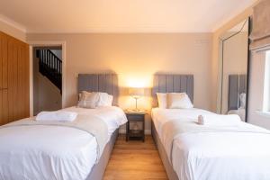 2 Betten nebeneinander in einem Zimmer in der Unterkunft Steels cross House in Lanark