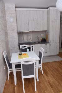 einen weißen Tisch und Stühle in der Küche in der Unterkunft Impressive Apartment in Nikšić