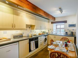 a kitchen with a wooden table and a table and chairs at 2 bed in Ramsgill 89166 in Bouthwaite